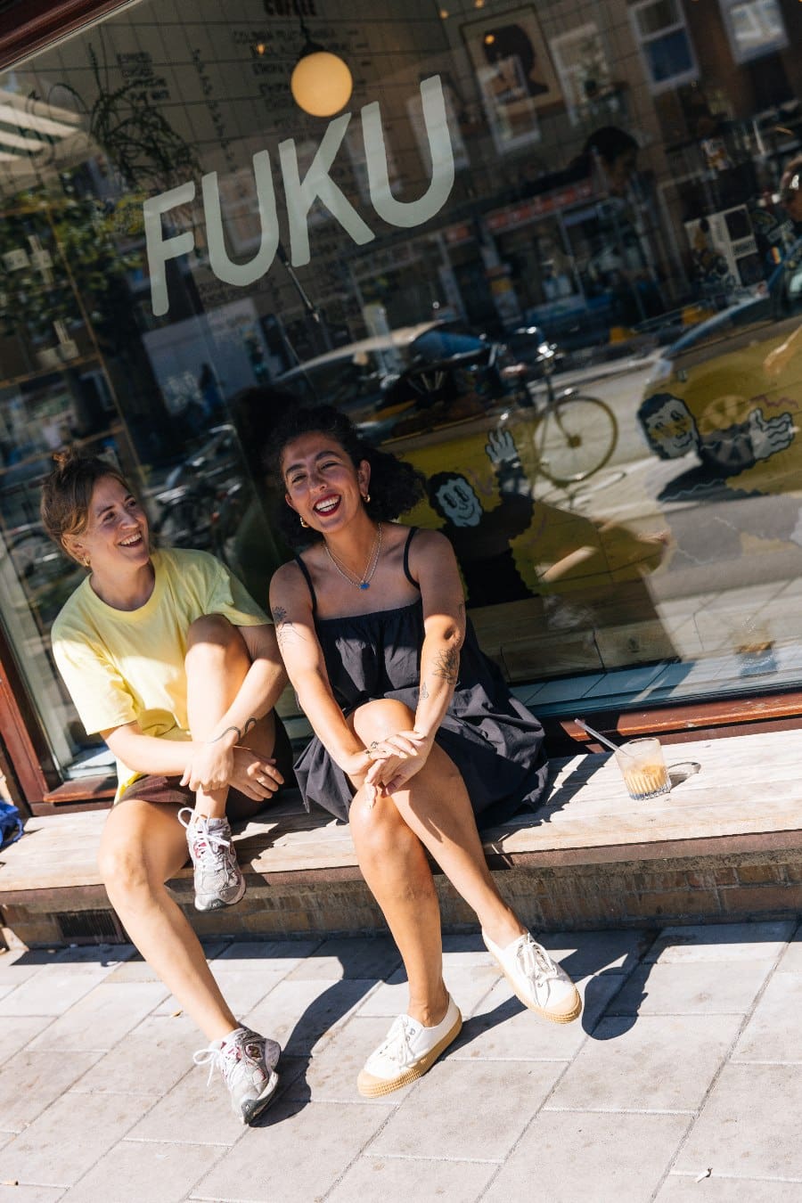 Two woman smiling outside Friedhats FUKU Cafe in Amsterdam