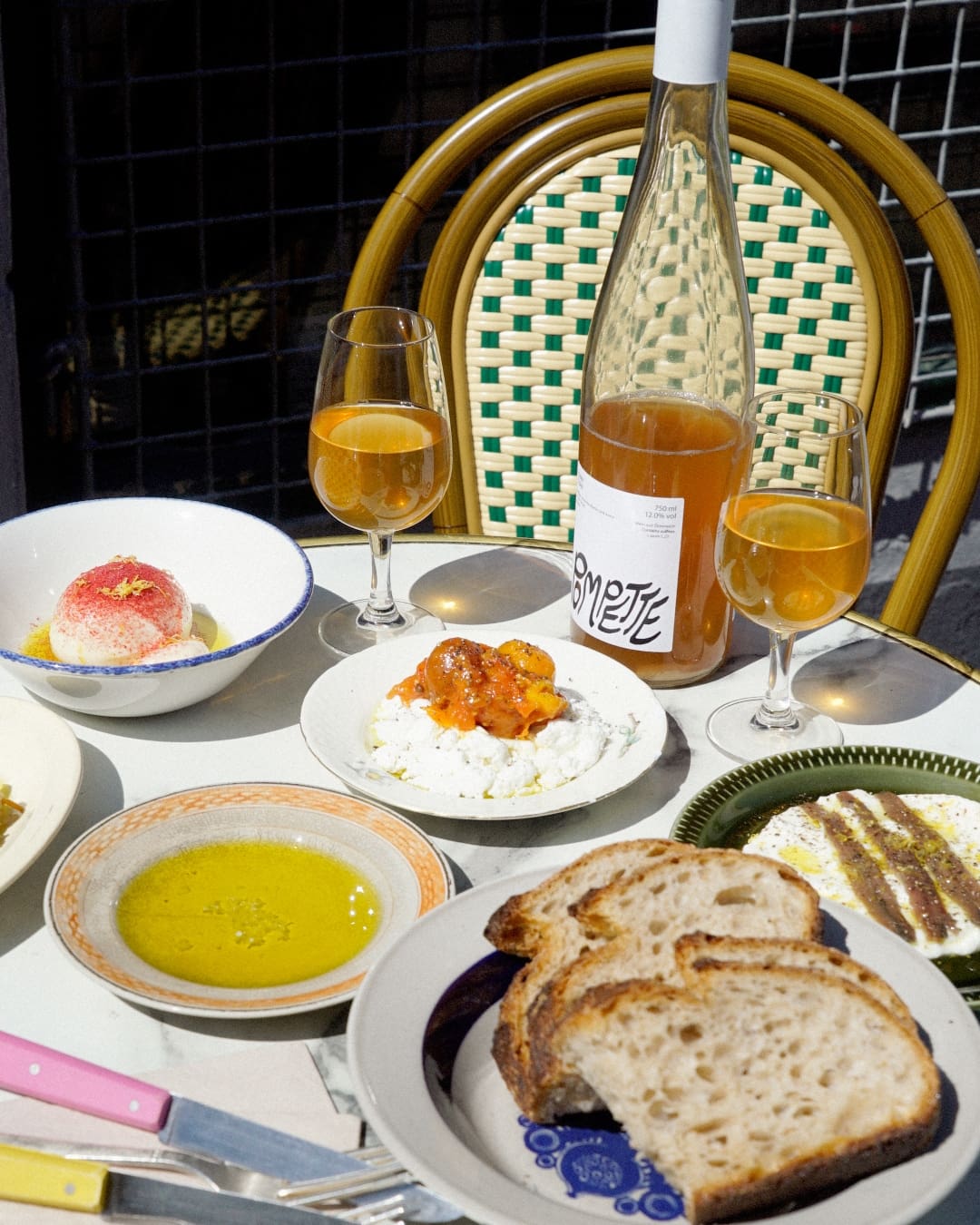 A pavement table at Pompette with plates and natural wine