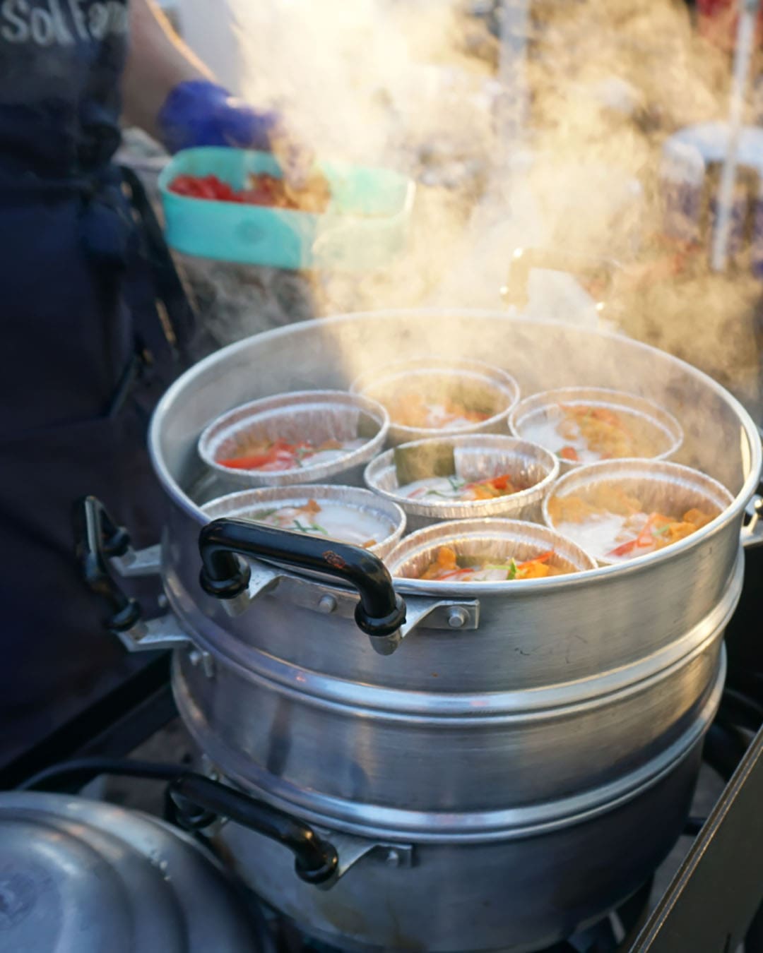 Smoke rises from outdoor cooking at Queens Night Market, New York