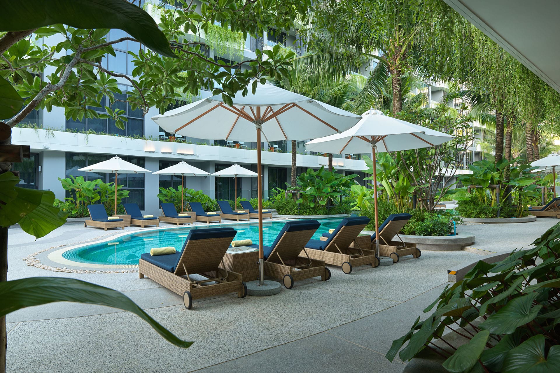 Sun lounges beneath tropical trees at Layan Green Park Phuket