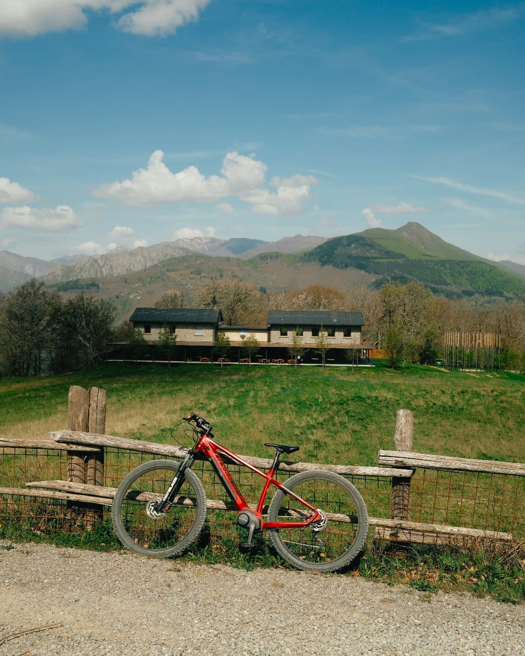 A red electric bike by a fence in Tuscany