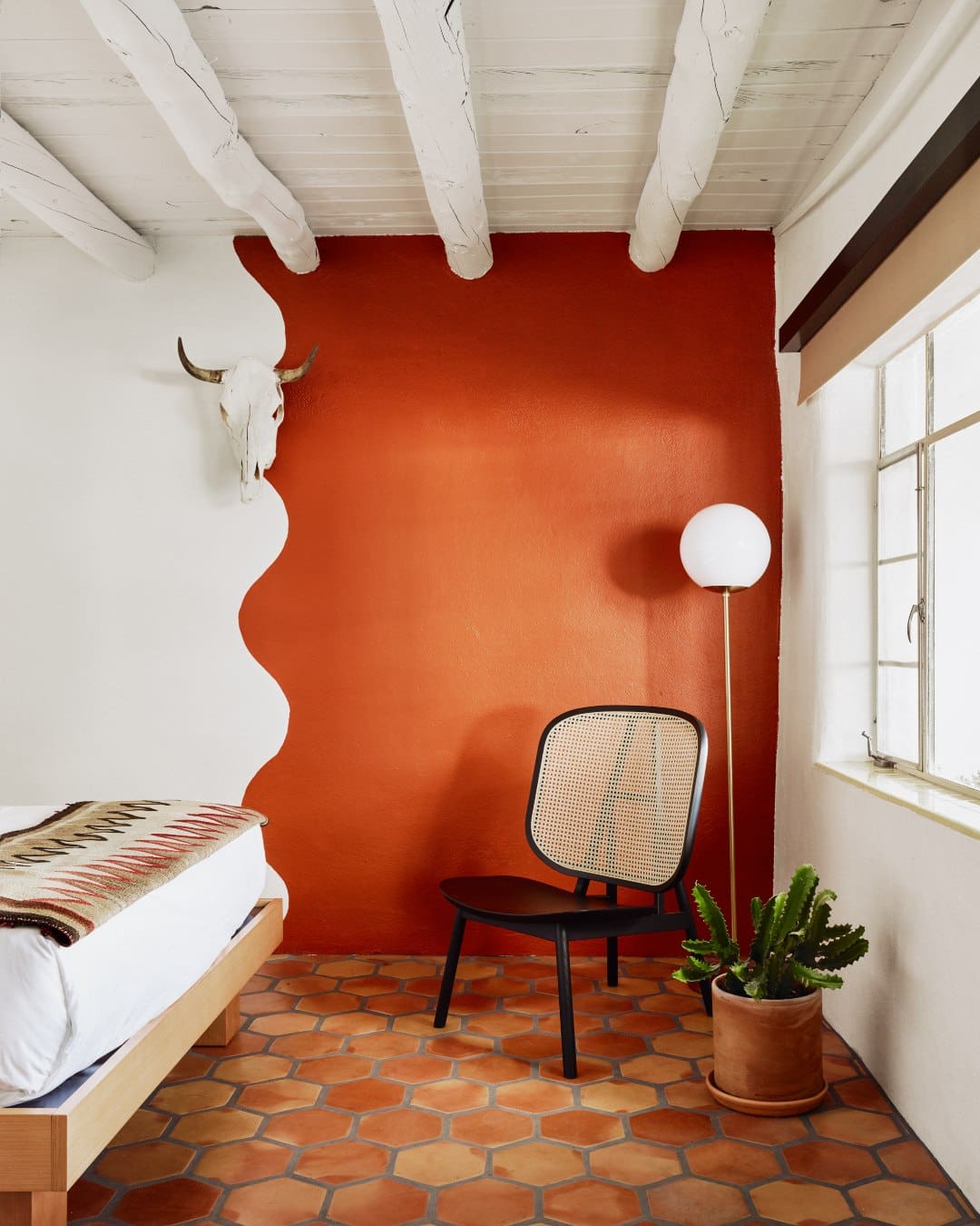 A chair by a dark red wall at El Rey Court
