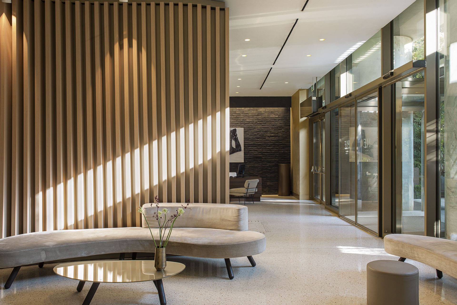 Light falls on a sleek wall divider in the lobby of Me Milan Il Duca