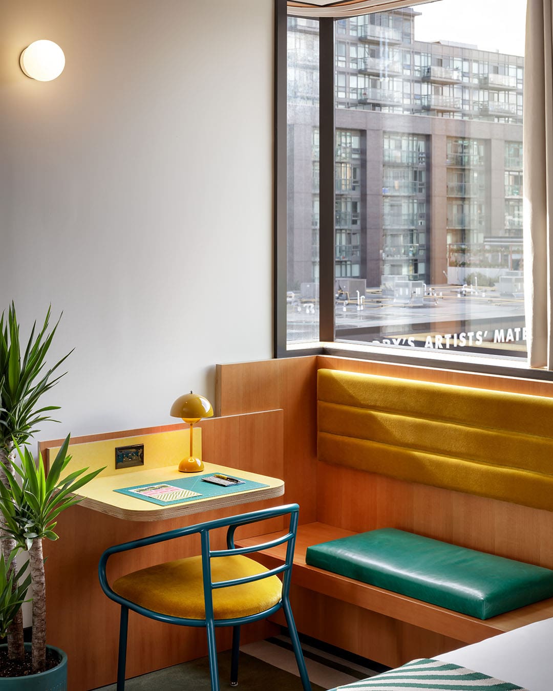 A table and chair in a colourful modern hotel room