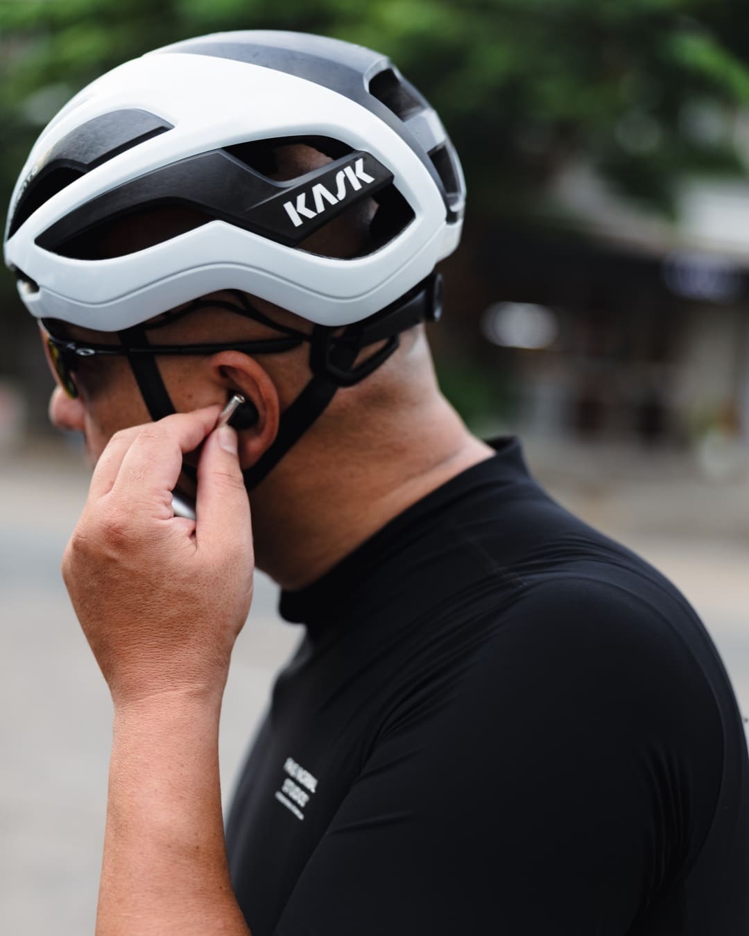A rider in a KASK helmet and Bang & Olufsen earbuds