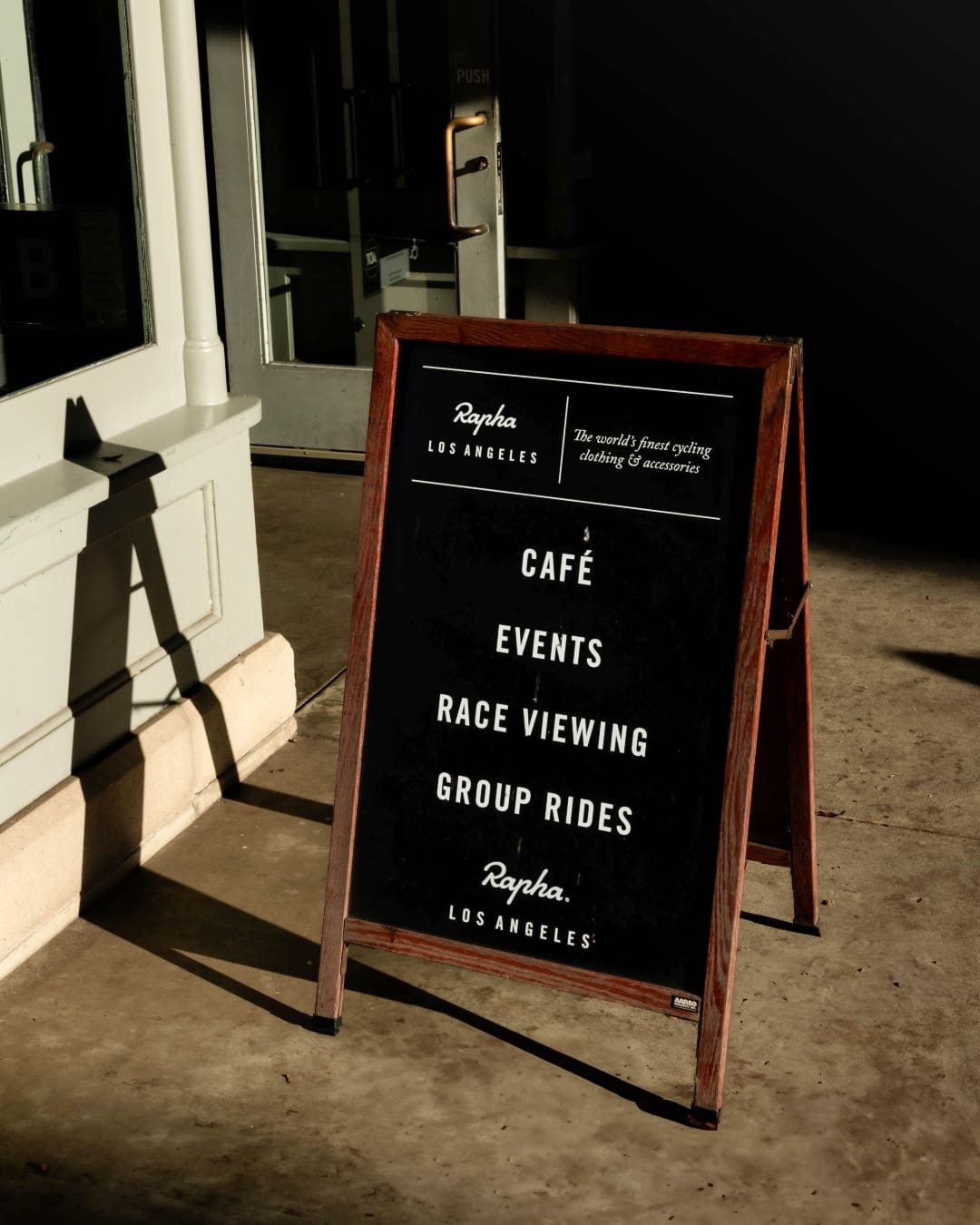 A sign outside the Rapha Clubhouse LA advertising coffee and rides