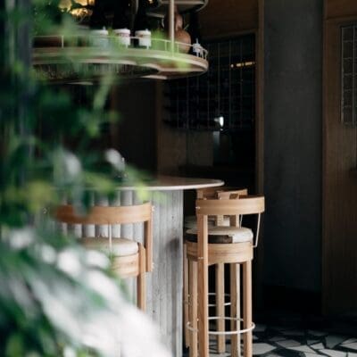 The best restaurants in Mexico City | A view of the bar at Malix, with a high wooden stool facing a curved counter, and a black-and-white checked floor