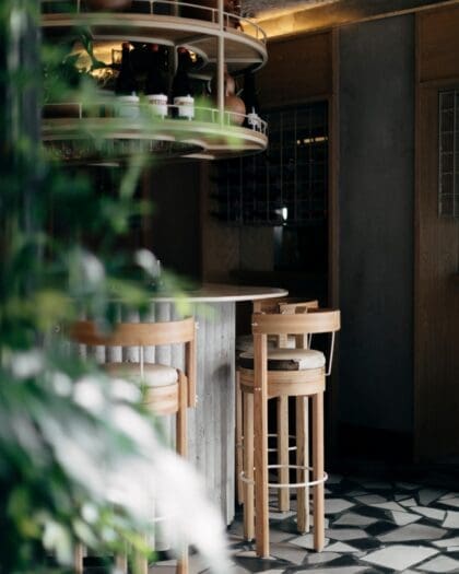 The best restaurants in Mexico City | A view of the bar at Malix, with a high wooden stool facing a curved counter, and a black-and-white checked floor