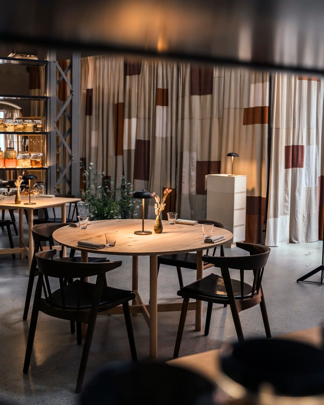 A wooden table and chairs in a warehouse space at Esse, Copenhagen
