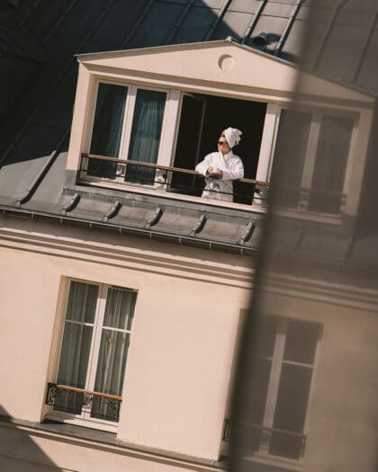 A woman in bathrobe enjoying a coffee on her balcony